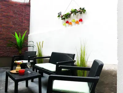 a patio with three chairs and a table with a glass of wine at Cosy Appartement met Tuin in Centrum Antwerpen - Gratis Parking & WiFi in Antwerp