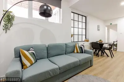 a living room with a blue couch and a table at Cosy Appartement met Tuin in Centrum Antwerpen - Gratis Parking & WiFi in Antwerp