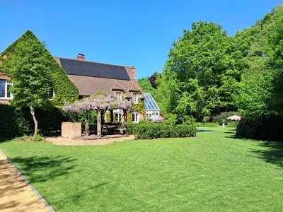 a house with a green yard with a gazebo at Het Bed van den Doktoor in Meerhout