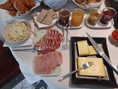 a table topped with plates of food with meat and cheese at Het Bed van den Doktoor in Meerhout