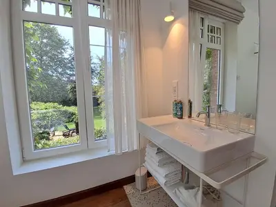 a bathroom with a sink and a large window at Het Bed van den Doktoor in Meerhout