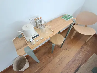 a wooden table with two chairs and a tea kettle on it at Het Bed van den Doktoor in Meerhout