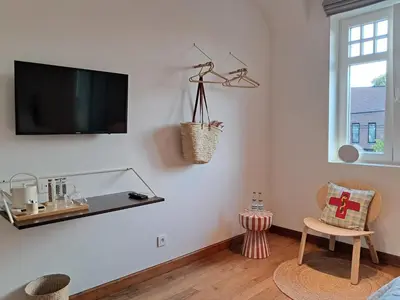 a living room with a flat screen tv on a wall at Het Bed van den Doktoor in Meerhout
