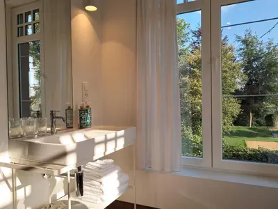 a bathroom with a sink and a window at Het Bed van den Doktoor in Meerhout