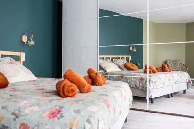 a bedroom with two beds and a mirror at Gezellig appartement op het hippe Zuid in Antwerp