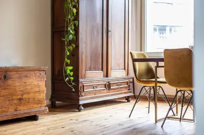 a dining room with a wooden cabinet and two chairs at Gezellig appartement op het hippe Zuid in Antwerp