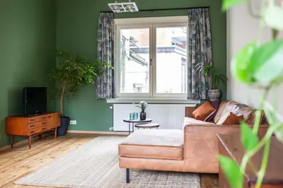 a living room with a couch and a window at Gezellig appartement op het hippe Zuid in Antwerp