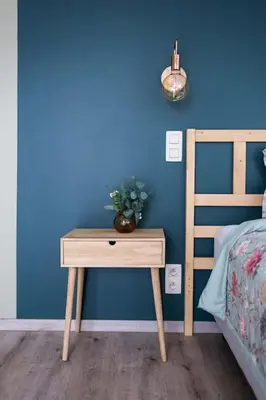 a table with a vase on it next to a bed at Gezellig appartement op het hippe Zuid in Antwerp