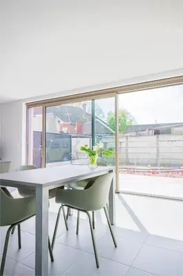 a dining room with a table and chairs and a window at Green HOME Wieze in Wieze