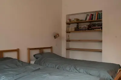 a bedroom with a bed and a book shelf at Het Bosnest, een vakantiewoning aan het Hallerbos in Halle