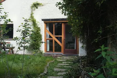 a wooden door of a house with a window at Het Bosnest, een vakantiewoning aan het Hallerbos in Halle