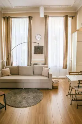 a living room with a couch and a large window at Appartement hôtel BRUXELLES CENTRE in Brussels