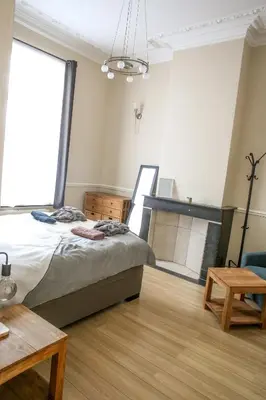 a bedroom with a bed and a table and a window at Appartement hôtel BRUXELLES CENTRE in Brussels