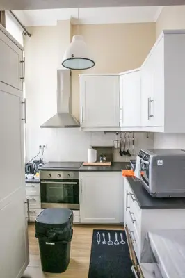 a kitchen with white cabinets and a black counter top at Appartement hôtel BRUXELLES CENTRE in Brussels