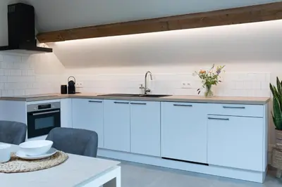 a kitchen with white cabinets and a sink at Cuypershof in Oosterzele