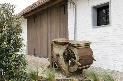 a wooden wheel sitting in front of a building at Cuypershof in Oosterzele