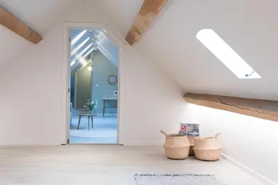 a room with white walls and wooden beams at Cuypershof in Oosterzele