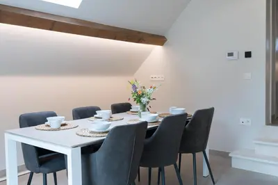 a dining room with a white table and chairs at Cuypershof in Oosterzele
