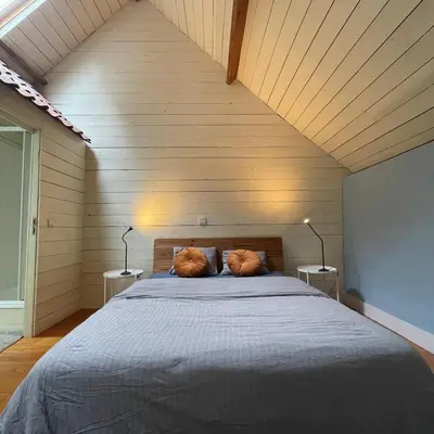 a bedroom with a bed with two pillows on it at The Cottage in Merelbeke