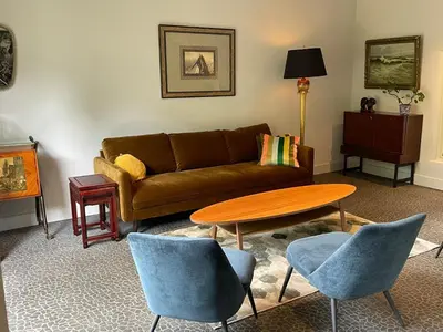 a living room with a couch and a table and chairs at The Cottage in Merelbeke