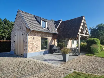 a brick house with a garage and a roof at De Mispel in Groot Schaddeken Dries