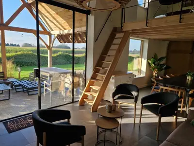 a room with a staircase and chairs and a table at De Mispel in Groot Schaddeken Dries