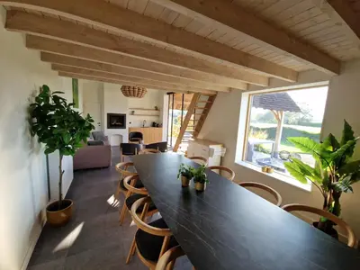 a dining room with a large black table and chairs at De Mispel in Groot Schaddeken Dries