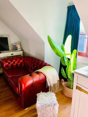 a red leather couch sitting in a living room at Zenitude in Tremelo