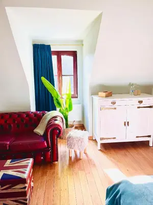 a living room with a red couch and a window at Zenitude in Tremelo