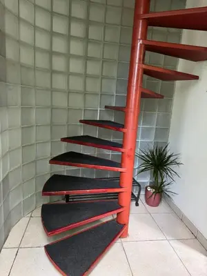a red spiral staircase in a room with a plant at Nilvaevents in Duffel
