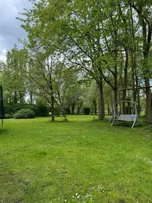 a swing set in a park with trees and grass at Nilvaevents in Duffel