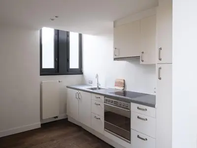 a white kitchen with white cabinets and a sink at CE RESIDENCE 2 in Ghent