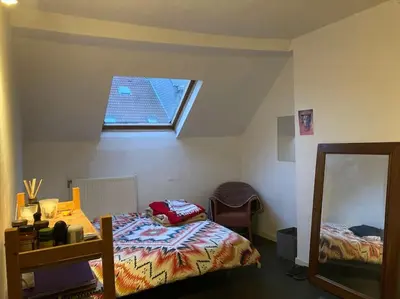 a bedroom with a bed and a mirror and a window at Duplex 3 chambres à Saint-Gilles in Brussels