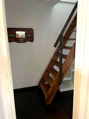 a stairway with a wooden rail and a stair case at Duplex 3 chambres à Saint-Gilles in Brussels