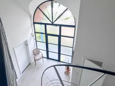 a spiral staircase with a large window in a room at Country Villa - Tervuren in Tervuren