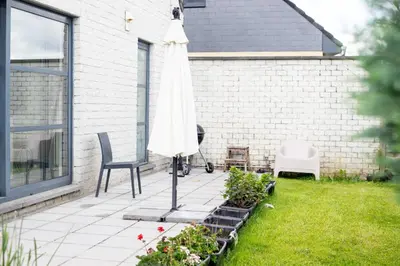 a patio with an umbrella and chairs and plants at Country Villa - Tervuren in Tervuren