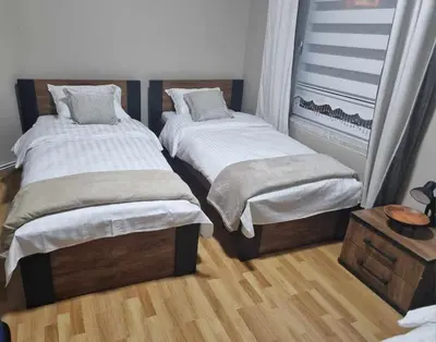 two twin beds in a room with wood floors at Guesthouse Djulia in Ghent