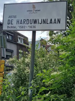 a street sign on a pole in front of trees at Guesthouse Djulia in Ghent
