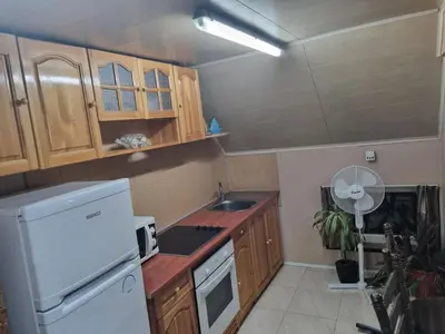 a kitchen with wooden cabinets and a white refrigerator at Guesthouse Djulia in Ghent