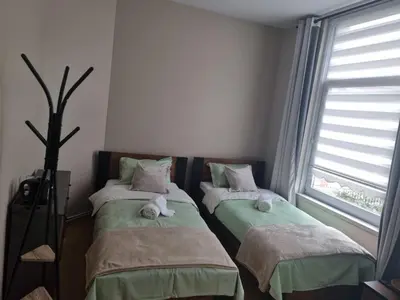 two twin beds in a room with two windows at Guesthouse Djulia in Ghent