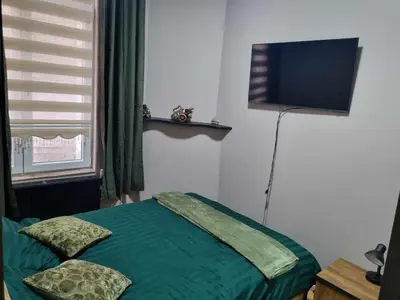 a bedroom with a bed and a flat screen tv at Guesthouse Djulia in Ghent