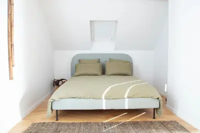 a bed in a room with a white wall at Galalith in Antwerp