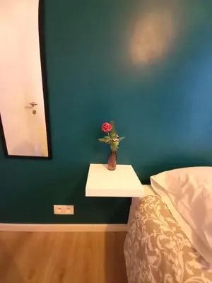 a table with a flower in a vase on a bed at Comfy Stay 9052 in Ghent