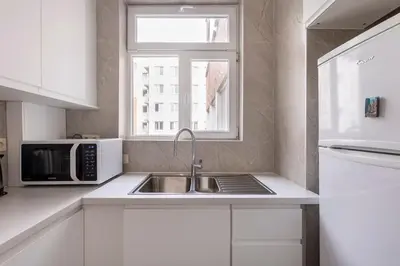 a kitchen with a sink and a microwave and a window at Antwerp Home Sweet Home 1 Double and 2 Single Beds in Antwerp