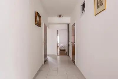 a hallway with white walls and a tile floor at Antwerp Home Sweet Home 1 Double and 2 Single Beds in Antwerp