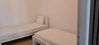 a room with two white beds and a stool at Antwerp Home Sweet Home 1 Double and 2 Single Beds in Antwerp