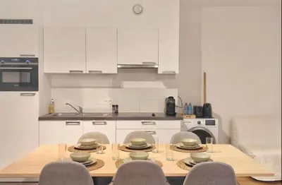 a kitchen with a table and chairs and a kitchen with white cabinets at 2 Bedroom Apartment in Center with Breathtaking View in Brussels