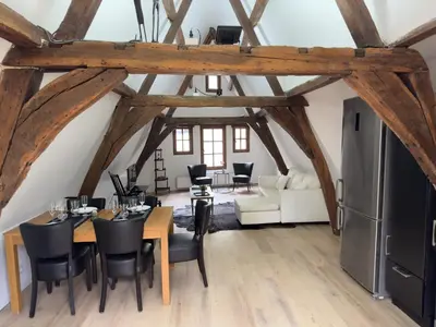 a dining room with a table and chairs and a living room at Loft with big terrace city center MEIR in Antwerp