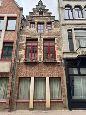 a brick building with red windows on a city street at Loft with big terrace city center MEIR in Antwerp
