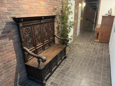 a wooden bench sitting next to a brick wall at Loft with big terrace city center MEIR in Antwerp